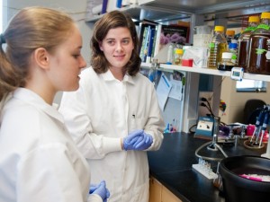 Two standing by lab bench