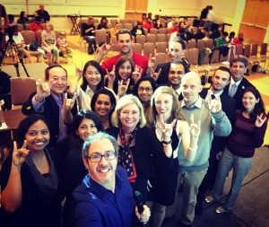 3MT Master of Ceremonies Brian Malow, front, snaps a photo of the 10 3MT finalists, judges and Graduate School Dean Maureen Grasso. +