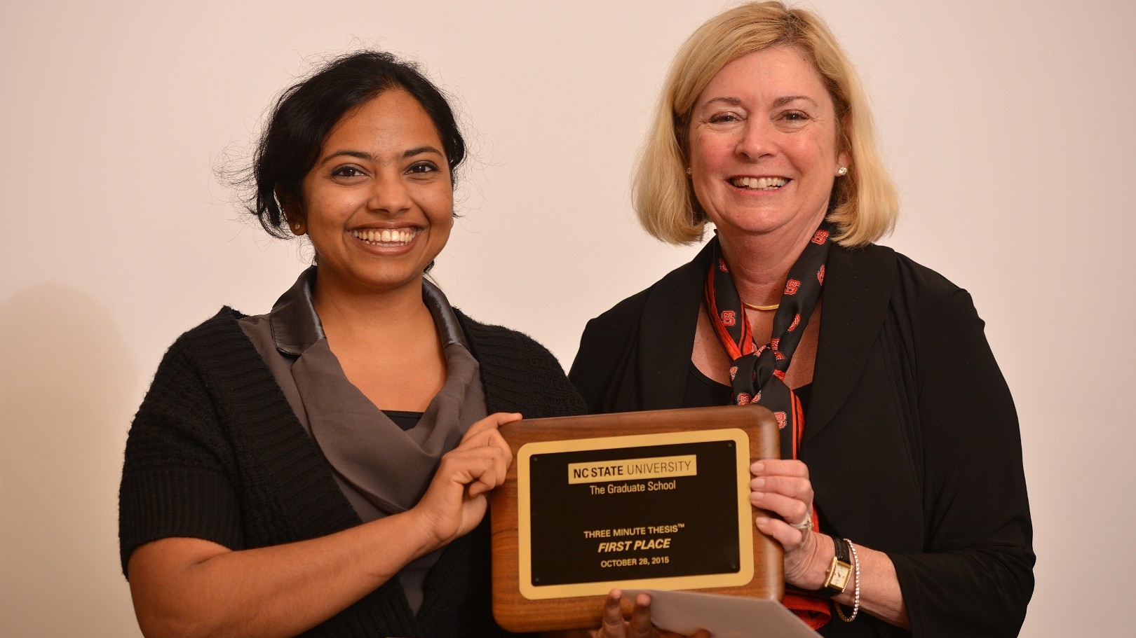 Haritha and Dean Grasso hold award plaque