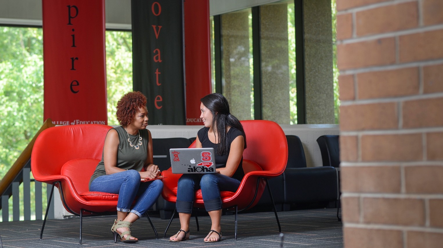 Two women talking in campus building