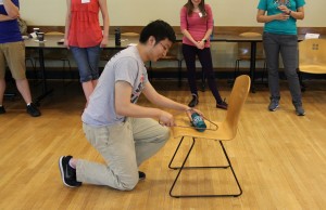 student using coat hanger to "cut" cup