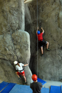 students climbing rock wall