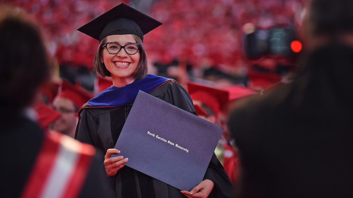 PhD graduate holds diploma