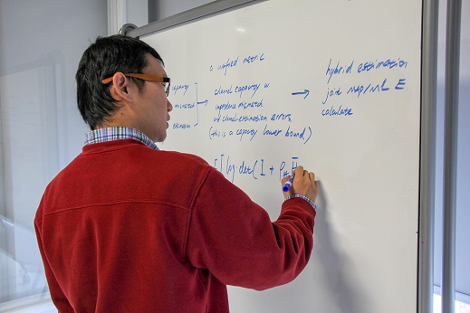 Image of a writer diagramming his thesis on a whiteboard