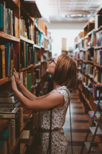 Woman surveying books in a library