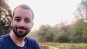 Tim Becker smiling at the camera with the forest in the background