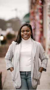 Chelsea Smith in a blazer and jeans, smiling at camera