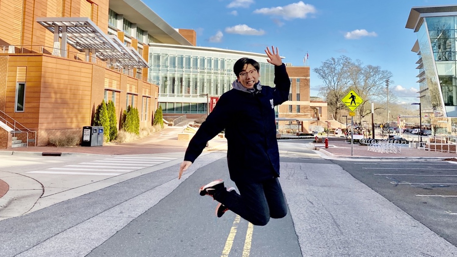 Yuseung Kim, M.S. computer engineering '22, leaps in front of James B. Hunt Library on Centennial Campus.