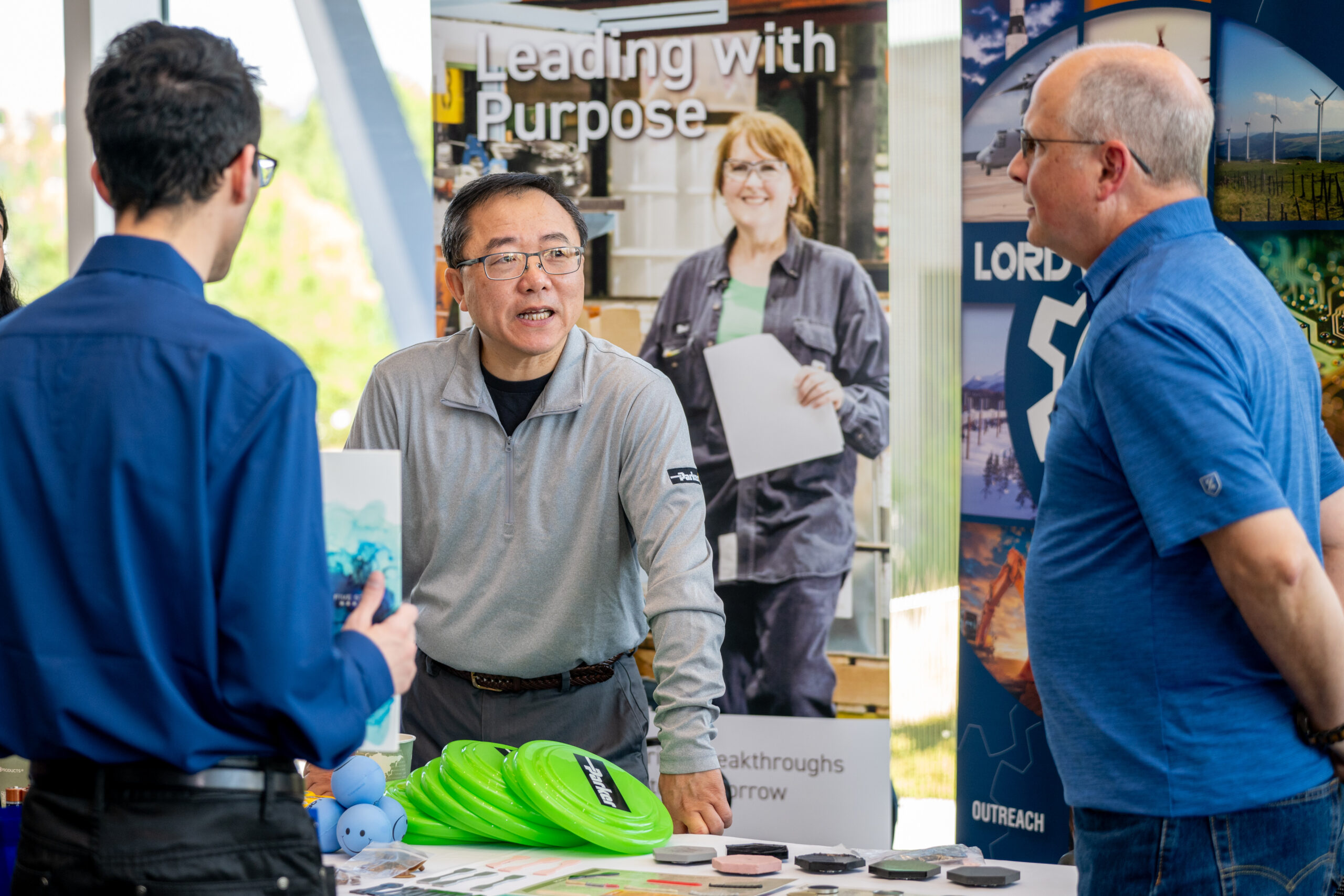 Three individuals talking at a NC State Career Fair.