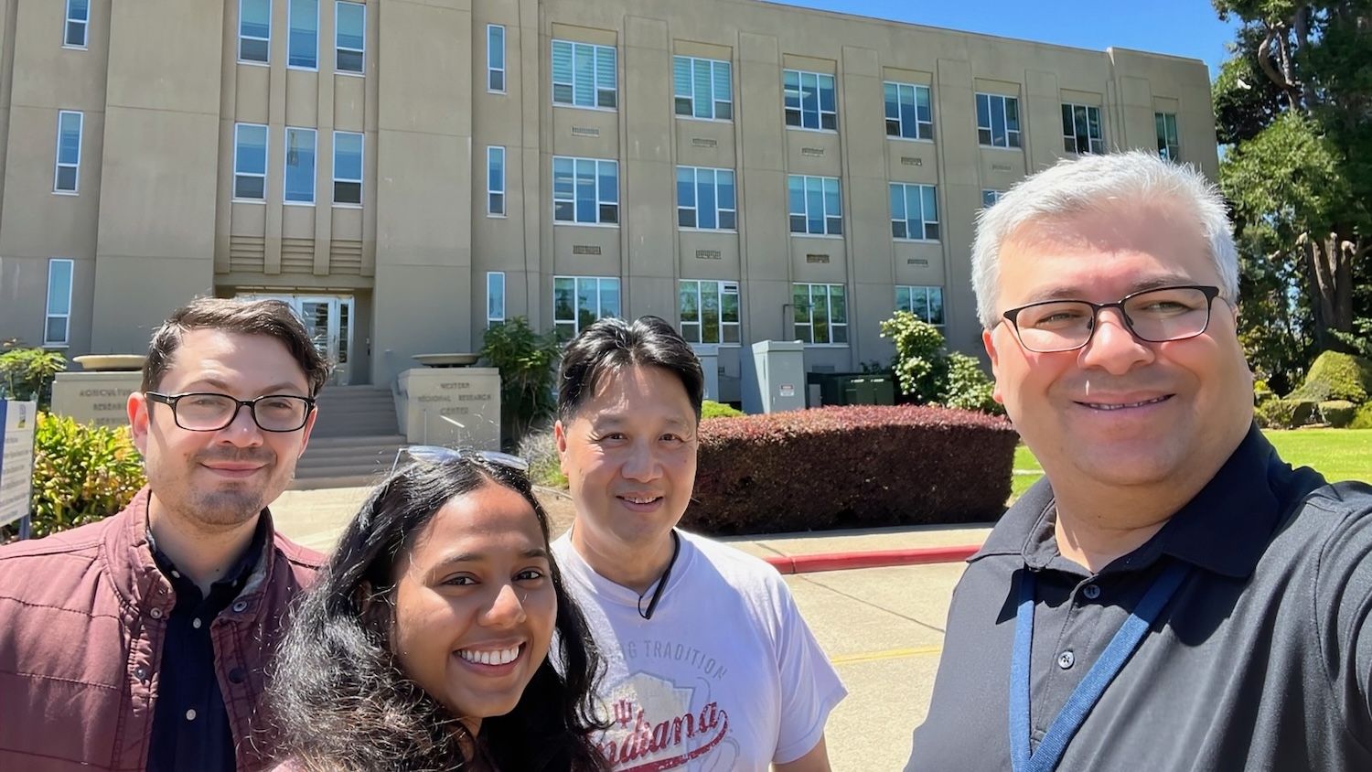 Four people standing in front of a USDA building