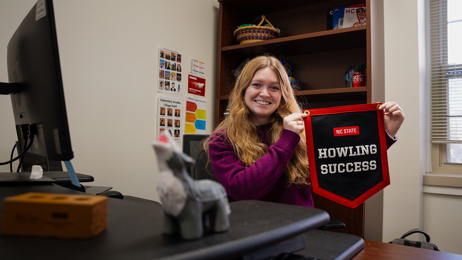 Ali Barrier proudly displays her Howling Success banner in her office in Owen Hall.