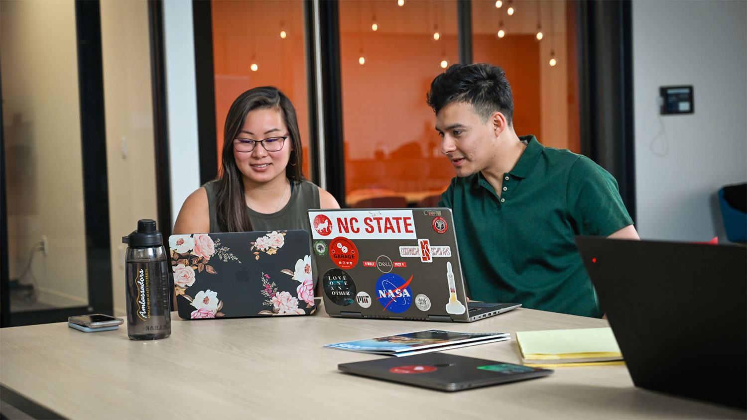 Two people working on laptops
