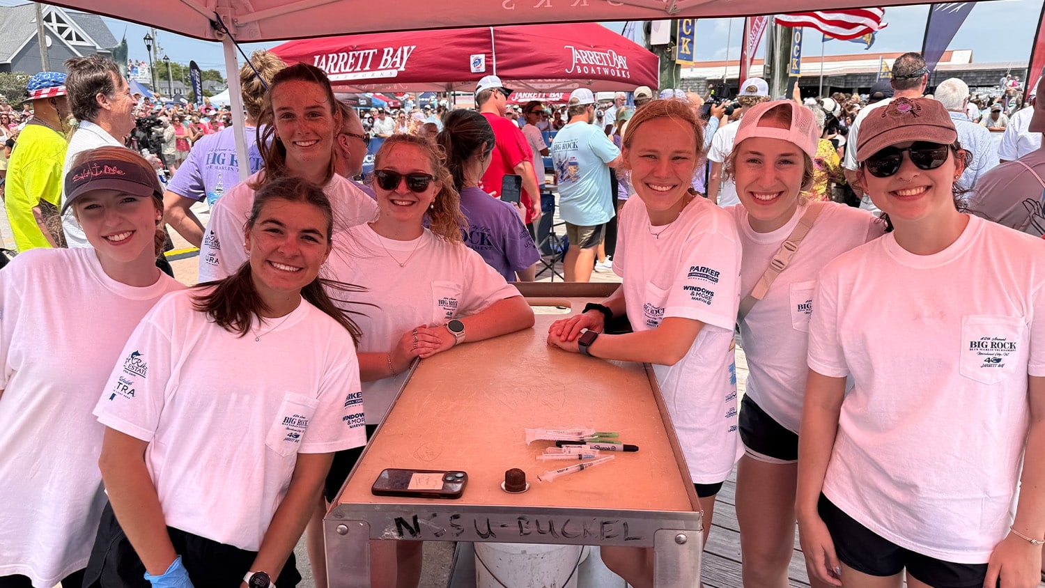 A group of students volunteering and doing research at a fishing tournament.