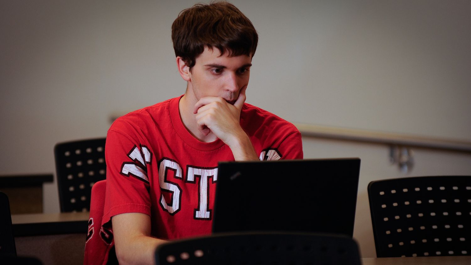 NC State student in classroom with laptop